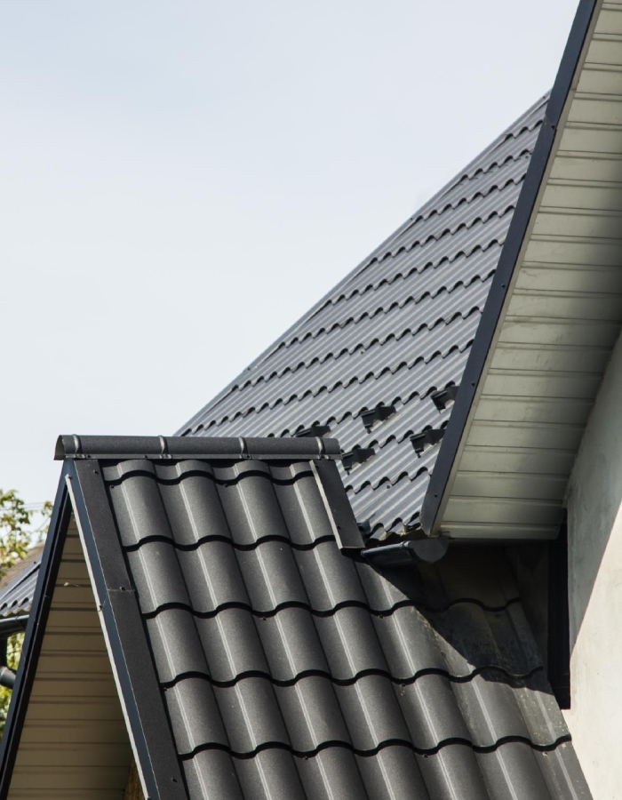 Toiture en tuiles anthracite avec finition de rive et évacuation des eaux pluviales