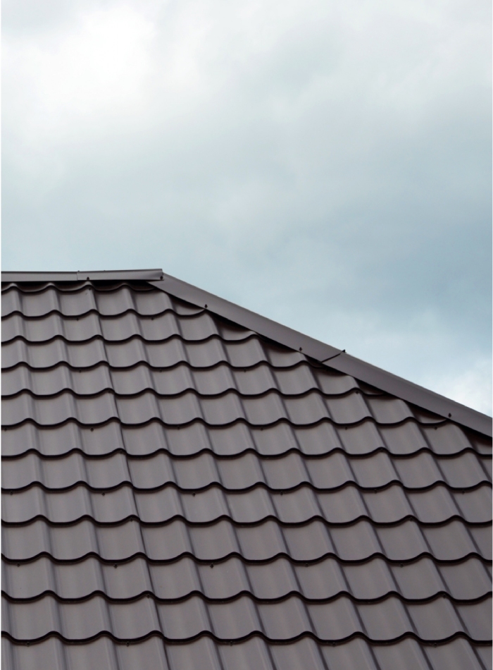 Toiture sombre en tuiles métalliques avec faîtage et finitions de rives