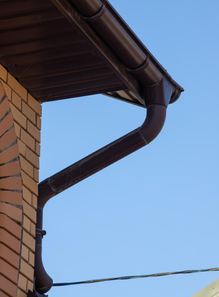Descente d’eau pluviale avec coudes et raccordement sous gouttière en façade